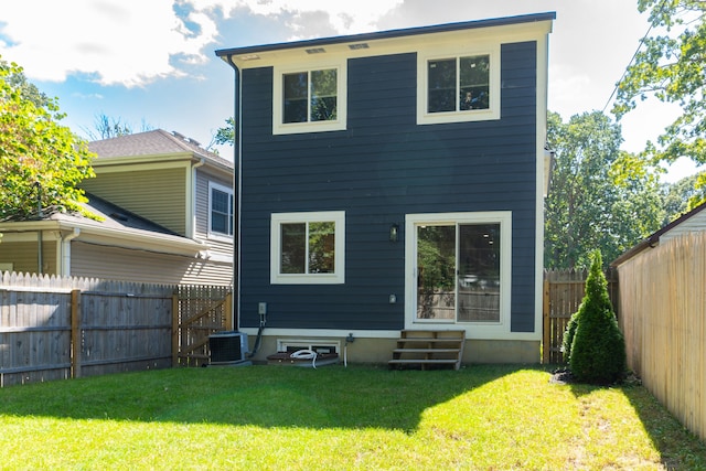 rear view of property with a lawn and central AC unit