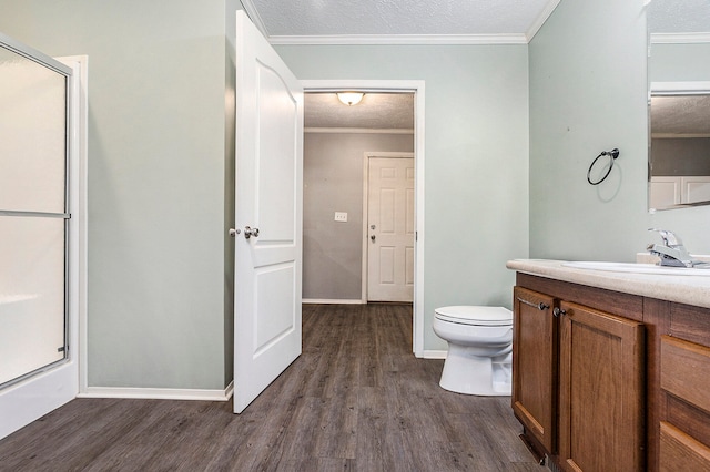 bathroom featuring ornamental molding, vanity, a textured ceiling, wood-type flooring, and a shower with shower door