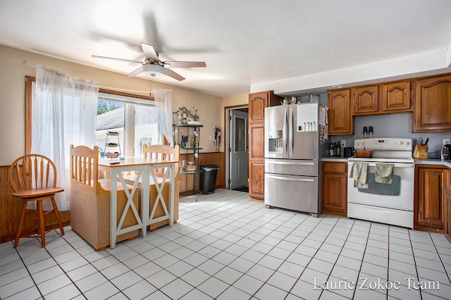 kitchen featuring stainless steel refrigerator with ice dispenser, light tile patterned floors, ceiling fan, and electric stove