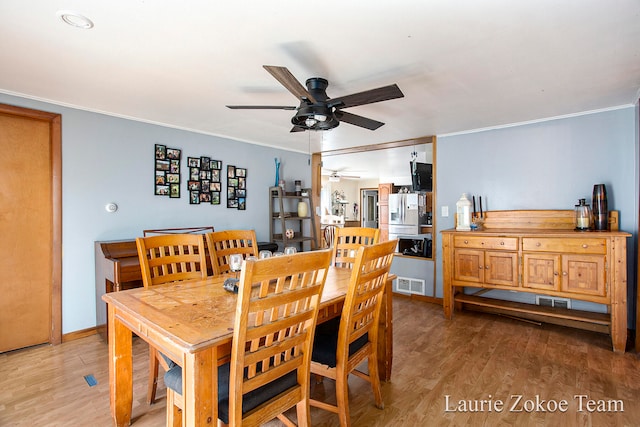 dining room featuring ceiling fan, light wood-type flooring, and crown molding