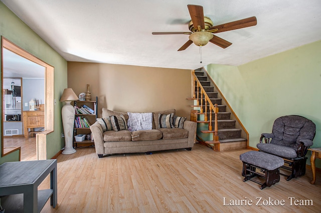 living room with light hardwood / wood-style flooring and ceiling fan