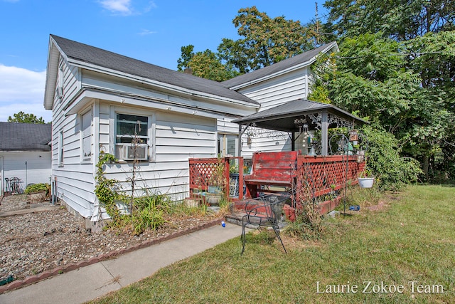 bungalow featuring a front yard and cooling unit