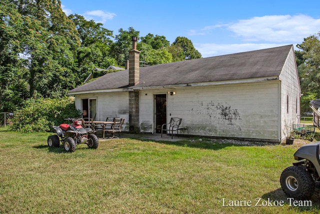 back of house with a lawn