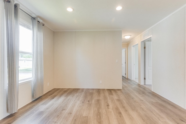 empty room featuring crown molding and light hardwood / wood-style flooring