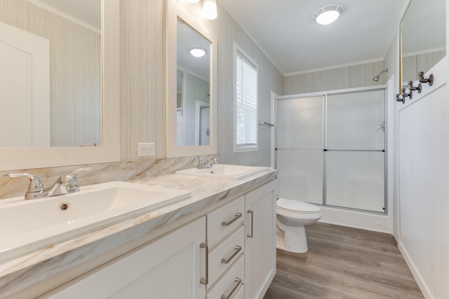 bathroom with walk in shower, toilet, hardwood / wood-style flooring, vanity, and ornamental molding