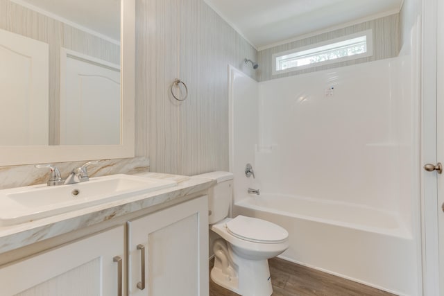 full bathroom featuring vanity, shower / washtub combination, crown molding, hardwood / wood-style floors, and toilet