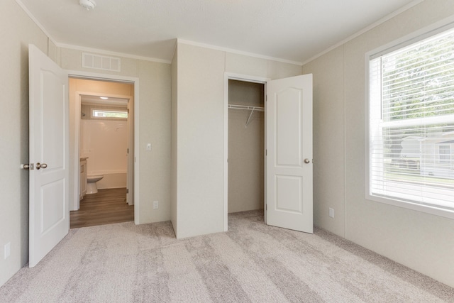 unfurnished bedroom featuring crown molding, a closet, and light colored carpet