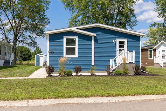 bungalow with a front yard and a storage unit