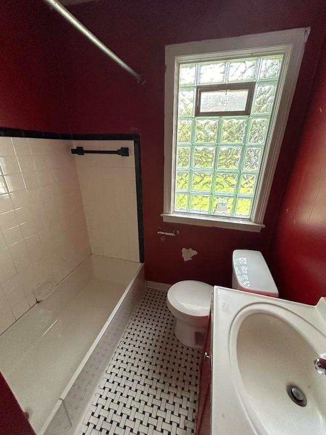 bathroom featuring tile patterned floors, vanity, toilet, and tiled shower