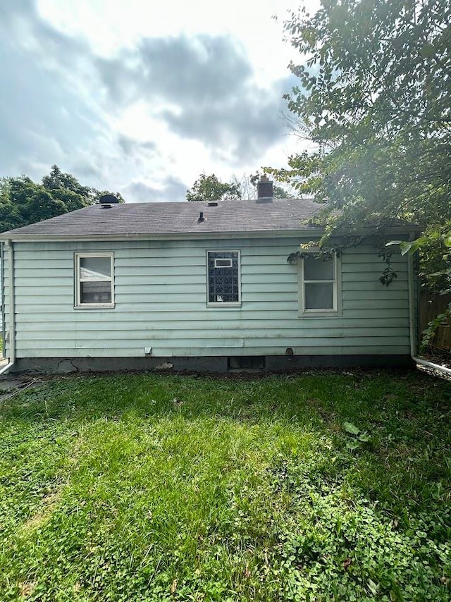 back of house featuring a lawn