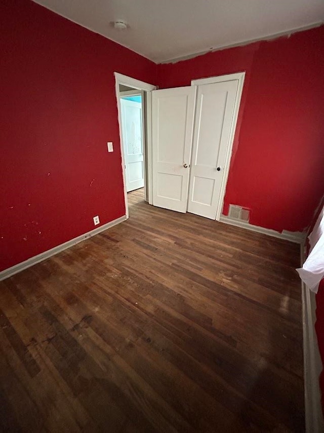 unfurnished bedroom featuring dark wood-type flooring