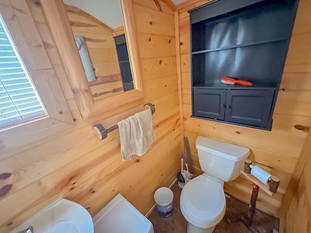 bathroom featuring toilet and wood walls