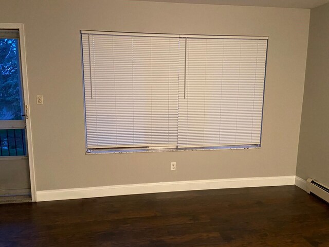 17161 Redford St Unit 203, Detroit, MI 48219 - empty room featuring baseboards, dark wood-type flooring, and baseboard heating