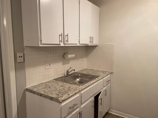 17161 Redford St Unit 203, Detroit, MI 48219 - kitchen featuring a sink, decorative backsplash, white cabinets, and baseboards