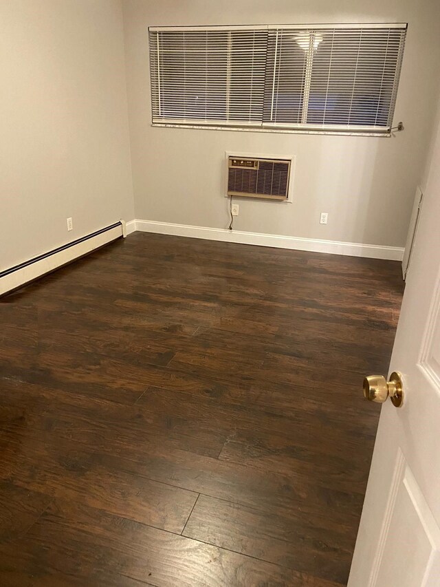 17161 Redford St Unit 203, Detroit, MI 48219 - spare room with wood finished floors, a wall mounted air conditioner, baseboard heating, and baseboards