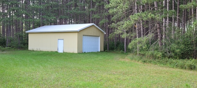 view of outdoor structure with a lawn and a garage