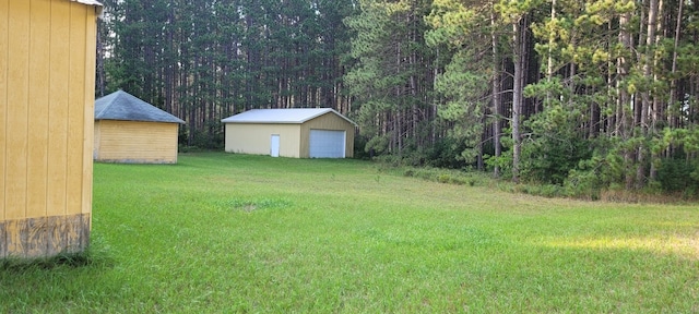 view of yard with a garage and an outdoor structure