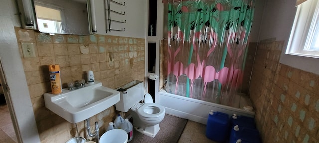 full bathroom featuring sink, toilet, shower / bathtub combination with curtain, and tile walls