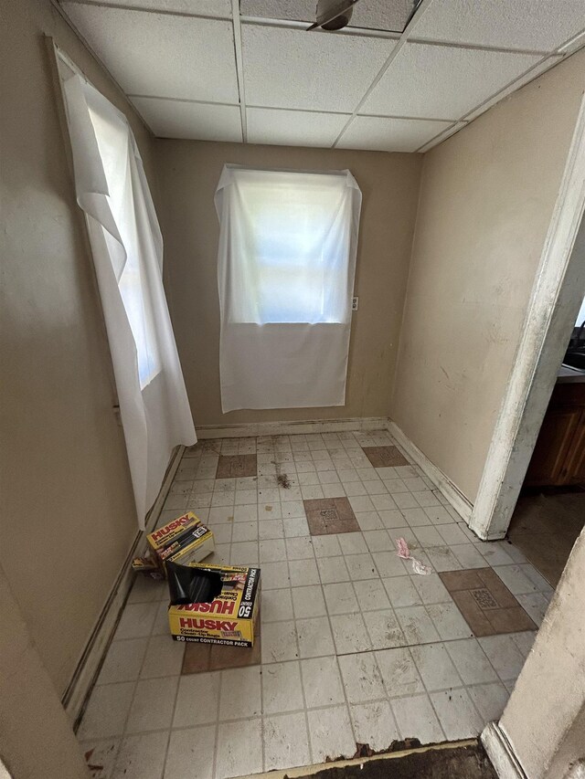 1028 Campbell St, Flint, MI 48507 - spare room with a drop ceiling, tile patterned floors, and baseboards
