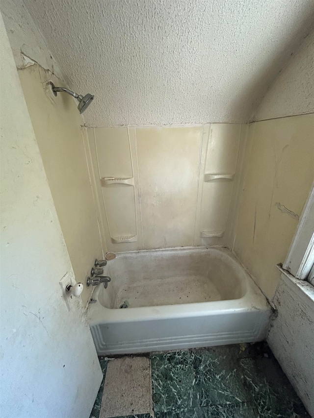 bathroom with shower / tub combination and a textured ceiling