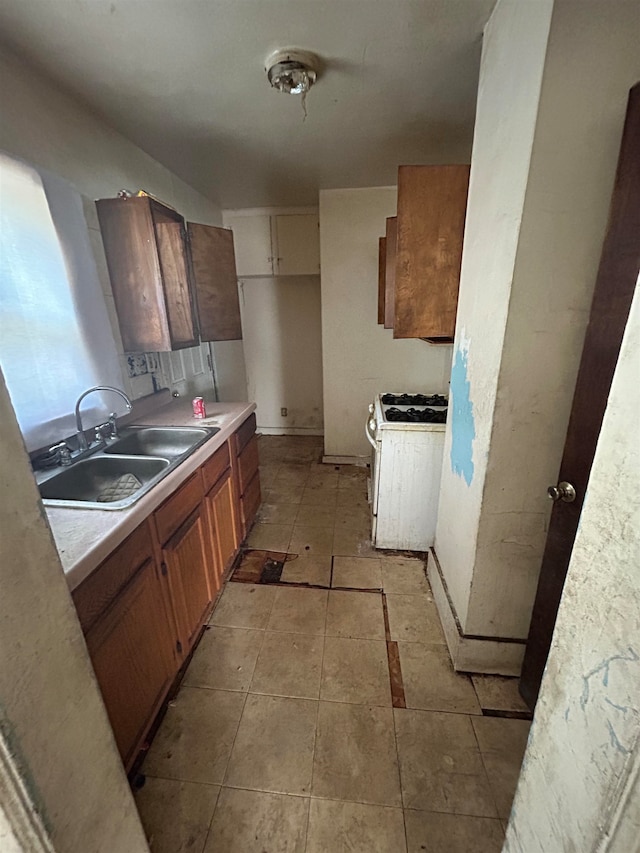 kitchen featuring white gas stove and sink