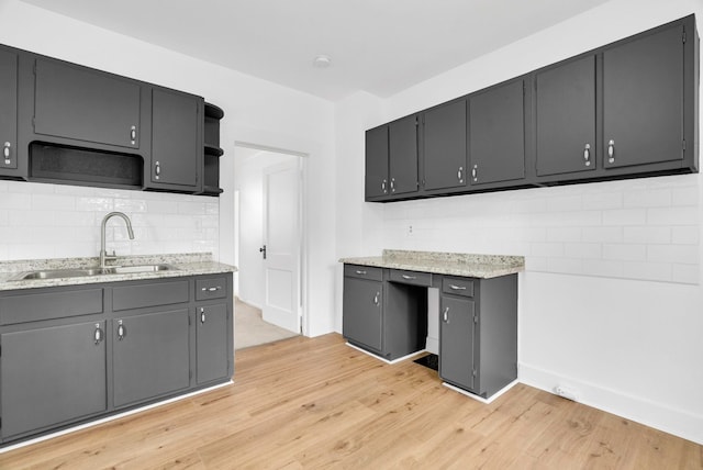 kitchen featuring gray cabinets, tasteful backsplash, sink, and light hardwood / wood-style flooring