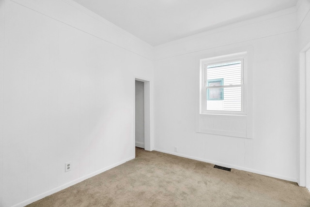 carpeted spare room with crown molding