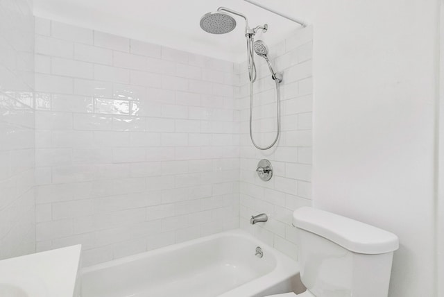 bathroom with tiled shower / bath combo and toilet