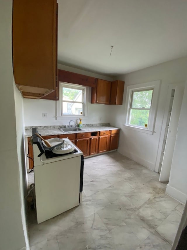 kitchen with electric range, sink, and a wealth of natural light