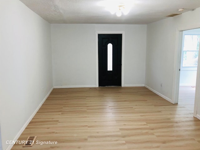 foyer featuring a textured ceiling and light hardwood / wood-style flooring