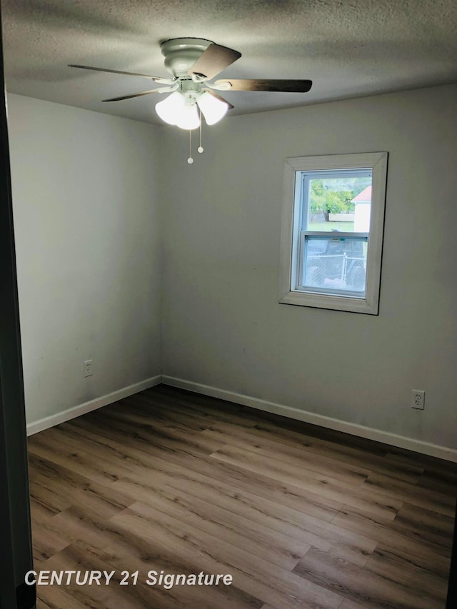 spare room featuring wood-type flooring and a textured ceiling