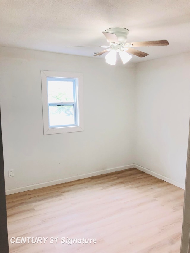 unfurnished room with a textured ceiling, light wood-type flooring, and ceiling fan