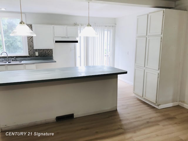 1540 Pound Dr, Flint, MI 48532 - kitchen featuring a sink, range hood, light wood finished floors, and healthy amount of natural light