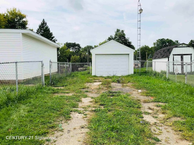 view of yard featuring a garage and an outdoor structure