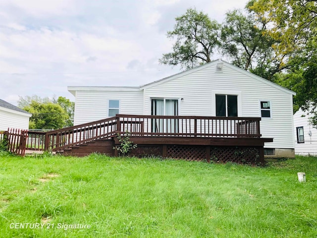 rear view of property featuring a lawn and a wooden deck