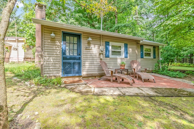 rear view of house with a lawn and a patio