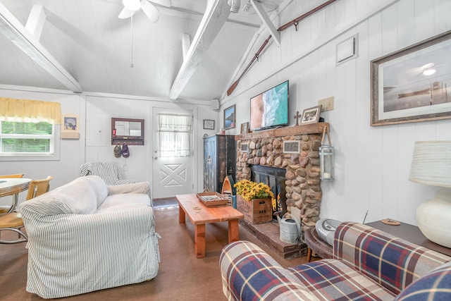 living room with vaulted ceiling with beams and a stone fireplace