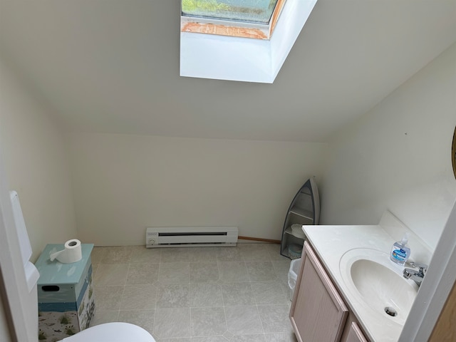 bathroom with vanity, a baseboard heating unit, and vaulted ceiling with skylight