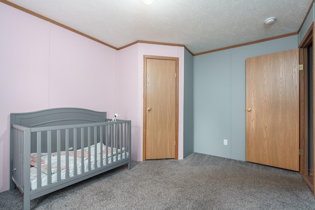 bedroom with a textured ceiling, carpet floors, and a crib