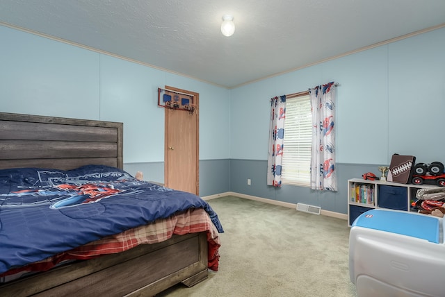 carpeted bedroom featuring a textured ceiling and crown molding