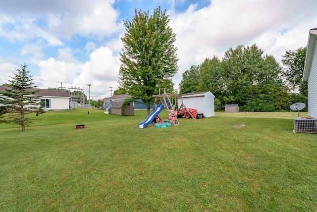 view of yard with central AC, a playground, and a shed