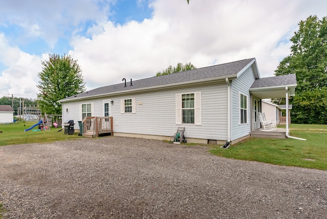 rear view of property featuring a lawn