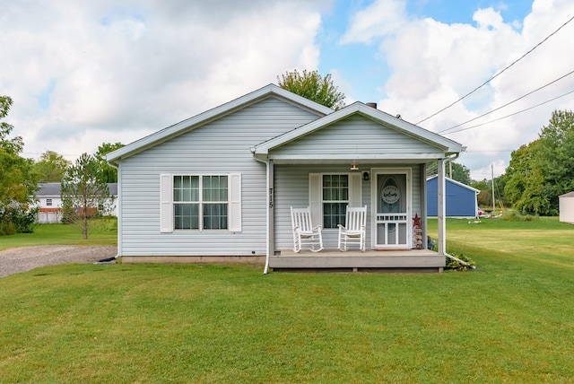 bungalow-style home with covered porch and a front yard