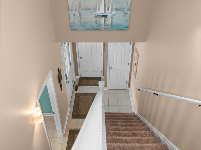 94 Charter Ct, Manistee, MI 49660 - staircase featuring tile patterned floors, baseboards, and a high ceiling