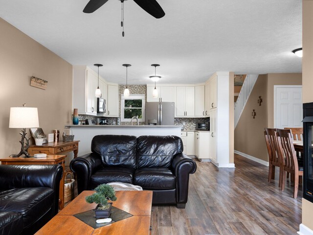 94 Charter Ct, Manistee, MI 49660 - living area featuring wood finished floors, a ceiling fan, baseboards, and stairway