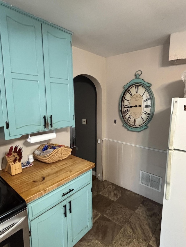 3329 120th Ave, Holland, MI 49424 - kitchen with freestanding refrigerator, arched walkways, wooden counters, blue cabinets, and electric stove