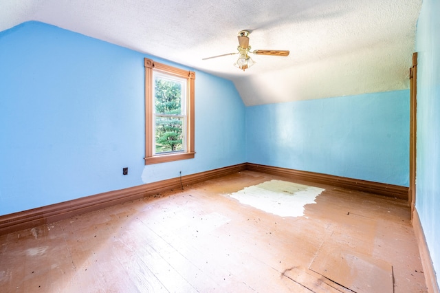 additional living space featuring ceiling fan, wood-type flooring, a textured ceiling, and vaulted ceiling