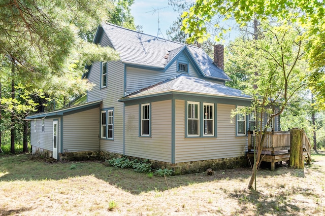 view of home's exterior featuring a yard and a deck