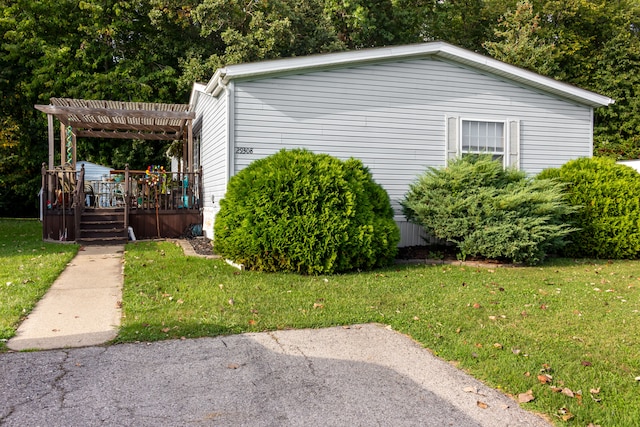 view of property exterior featuring a deck, a pergola, and a yard