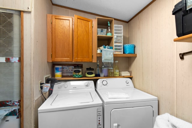 clothes washing area with crown molding, washer and clothes dryer, cabinets, and a textured ceiling